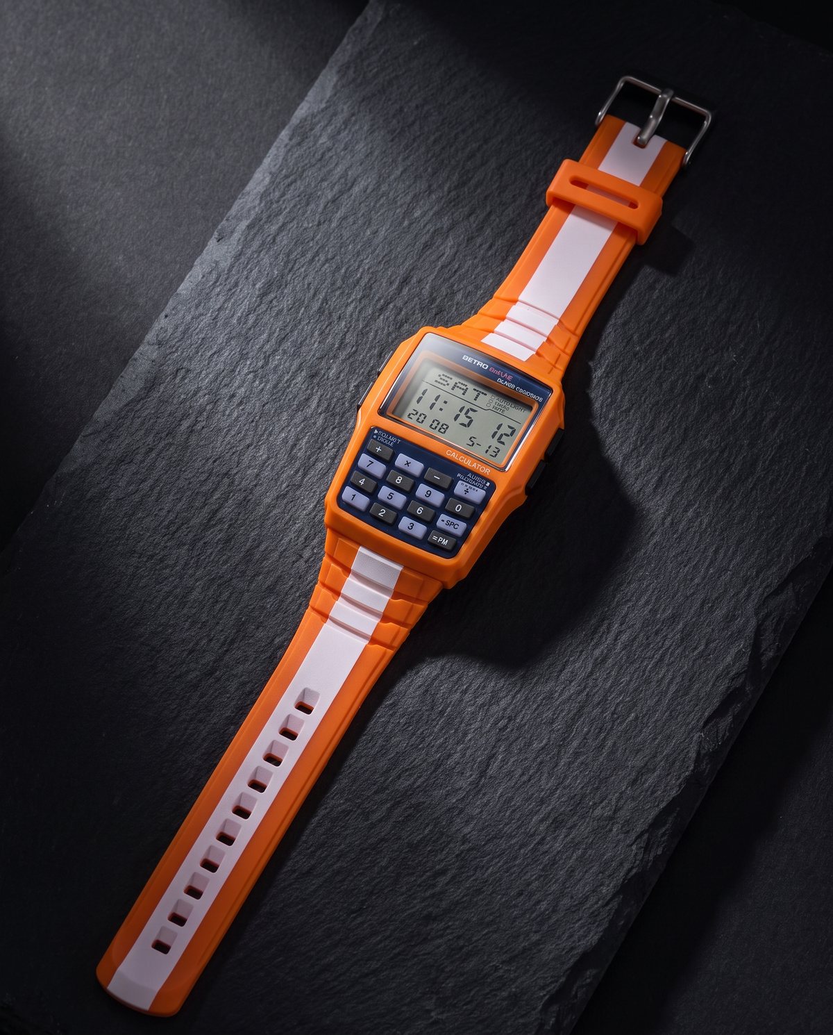 RetroWave watch laid flat on dark stone under a hard studio light